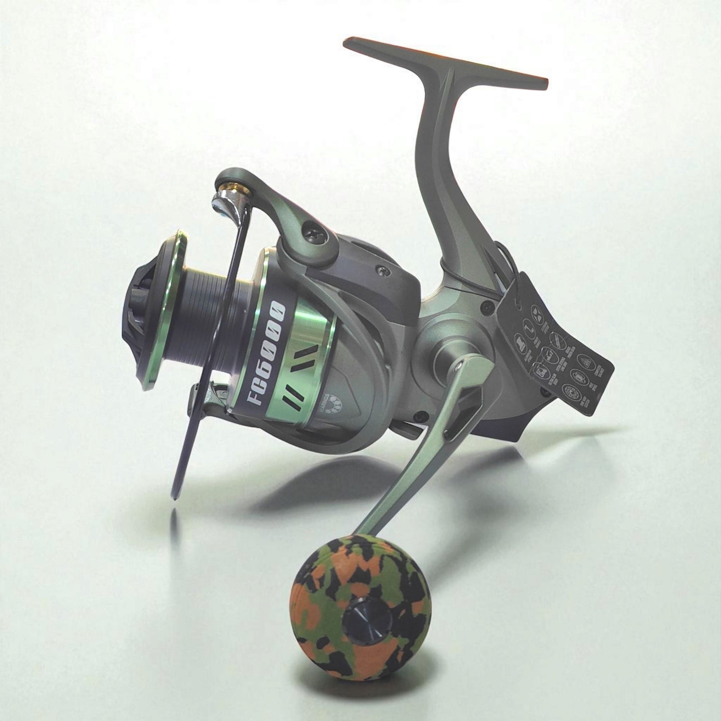FC6000 heavy duty spinning fishing reel in military green with camouflage EVA grip, high drag power and durable build for freshwater and saltwater anglers