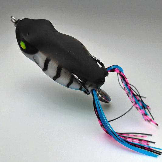 Soft hollow-body frog bait with silicone skirt legs and hidden steel hooks – ideal for weedless surface fishing in shallow waters
